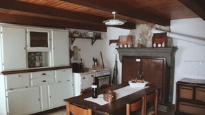 Une cuisine avec des meubles en bois, une table à manger et une cheminée.