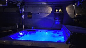Ein Whirlpool mit blauer Beleuchtung in einer zeltartigen Struktur.