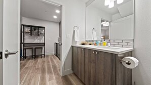 A modern bathroom with a large mirror, wooden cabinets, and a white countertop. - Lake Oswego Quiet Ground Level Condo Private Entrance - Pet Friendly! (Lake Oswego)