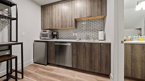 A modern kitchen with wooden cabinets, a built-in oven, a dishwasher, and a brick backsplash. - Lake Oswego Quiet Ground Level Condo Private Entrance - Pet Friendly! (Lake Oswego)