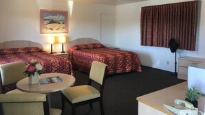 A hotel room with two beds, a desk, a chair, a lamp, a telephone, and a painting on the wall. - Old Marina Inn (Marina)