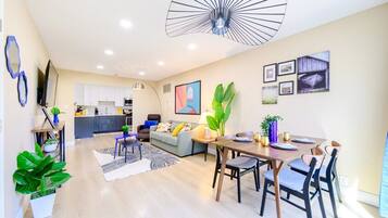 Un appartement moderne comprenant un coin repas, une cuisine et un espace de vie.