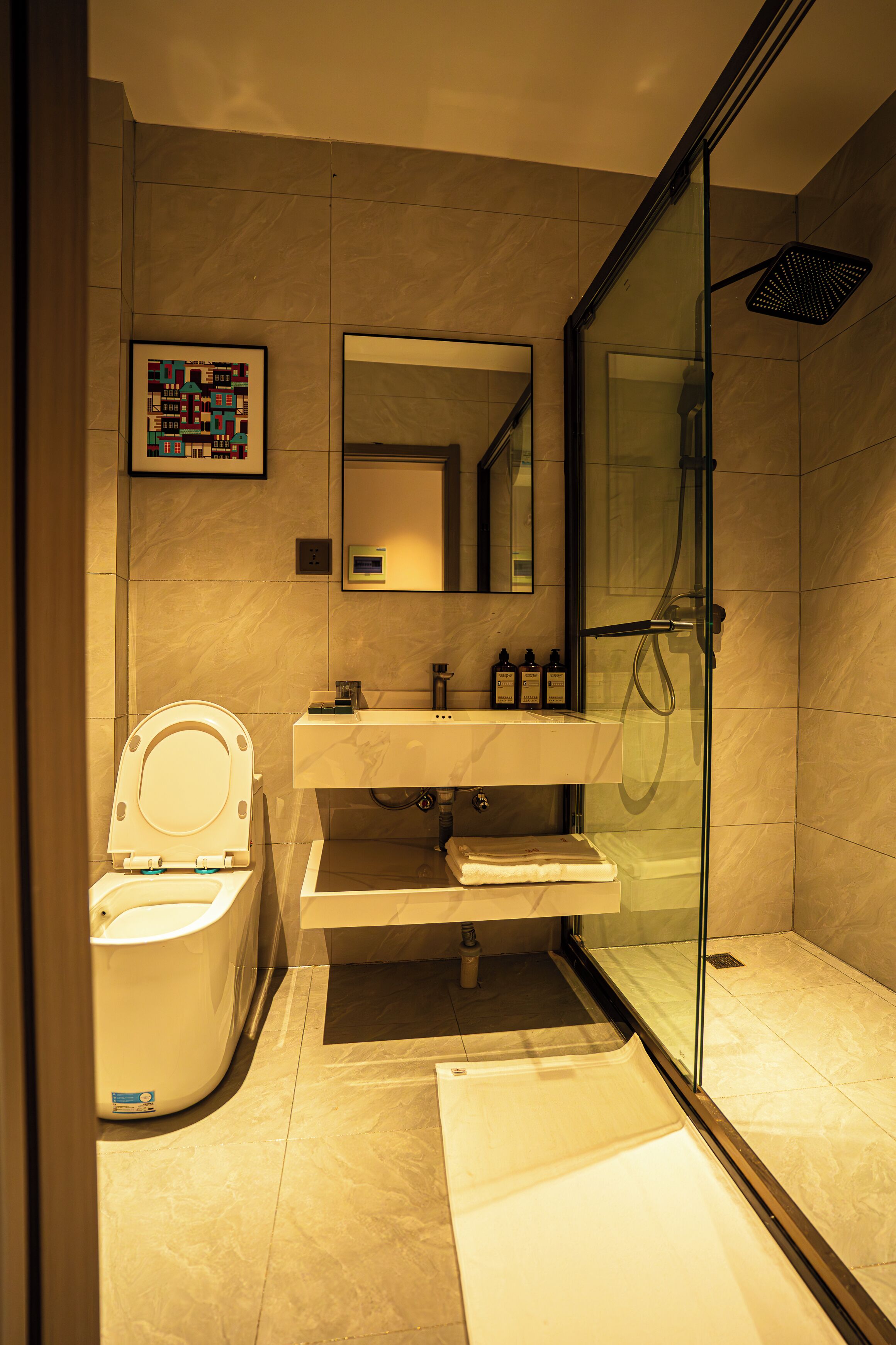A modern bathroom with a toilet, sink, and glass-enclosed shower.