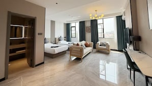 Une chambre d’hôtel moderne équipée d’un grand lit, d’un canapé, d’une table à manger et d’un téléviseur.
