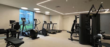 A gym with treadmills, elliptical machines, and weightlifting equipment.