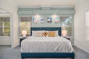 A bedroom with a bed, two bedside lamps, a headboard, and four wall-mounted pictures. - Guadalupe Riverfront Retreat | Sleeps 10 Kerrville (Kerrville)