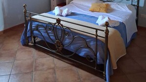 A bedroom with a metal bed frame, a bedside table, and a nightstand.