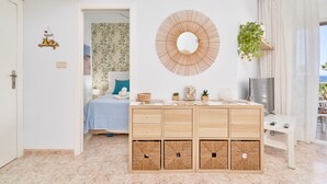 A modern bedroom with a bed, a wooden dresser, a TV, and a view of the outdoors. - Apartment 'Góndolas Costa Tropical' with Sea View, Wi-Fi and Air Conditioning (ALMUÑECAR)