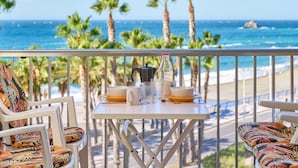 A balcony with a table set for two, overlooking a beach with palm trees and the ocean. - Apartment 'Góndolas Costa Tropical' with Sea View, Wi-Fi and Air Conditioning (ALMUÑECAR)