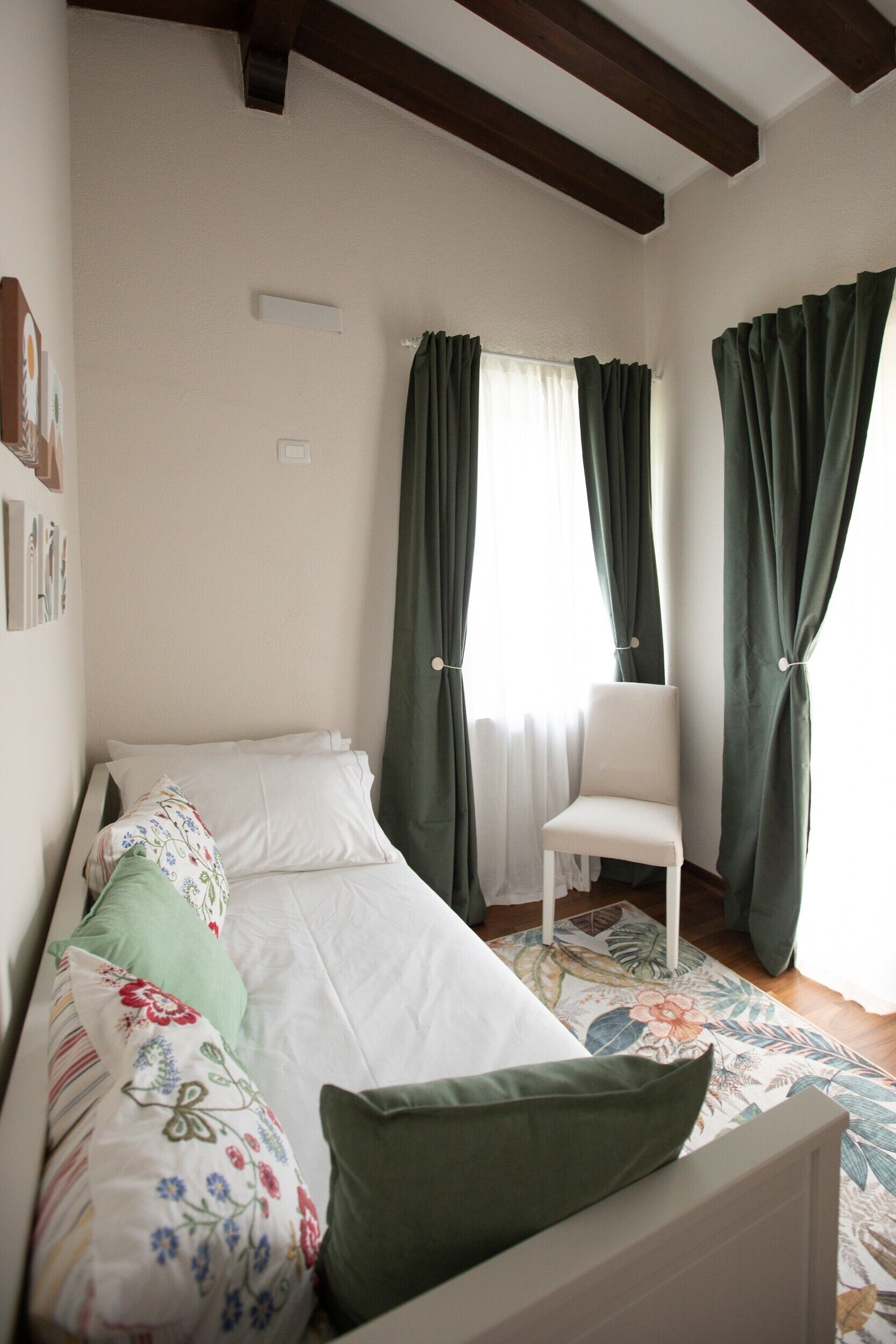 Ein Schlafzimmer mit einem Bett, einem Sessel und Vorhängen.