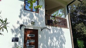 Un bâtiment avec une porte en bois, un balcon doté d’une balustrade et une enseigne indiquant « AGRICURISMO LA OINESTRA ENTRADA ».