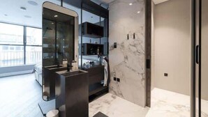 A modern bathroom with a large mirror, marble walls, and a glass shower enclosure. - Monochrome Majesty - Soho - by Frankie Says (London)