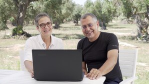 Two people sitting at a table with a laptop, outdoors with trees in the background. - Giardino del Tempo (Lizzanello)