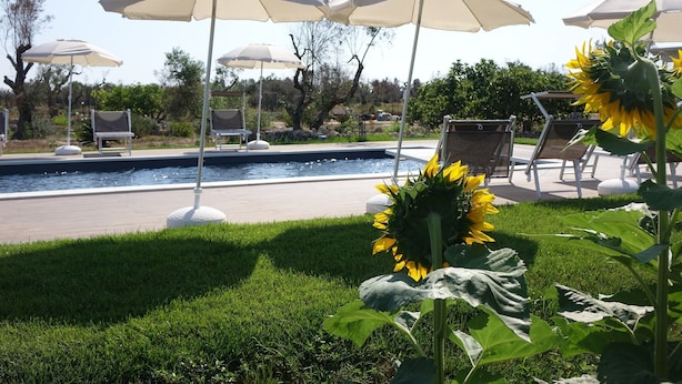 A poolside area with lounge chairs and umbrellas. - Giardino del Tempo (Lizzanello)