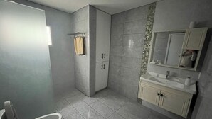 Un bagno con il water, un lavandino e uno specchio.