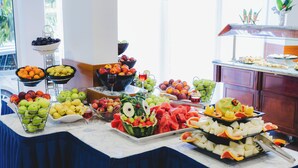 A buffet table with various fruits and a watermelon centerpiece.
