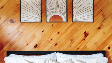 A wooden floor with three framed artworks depicting sun rays and a crescent moon.