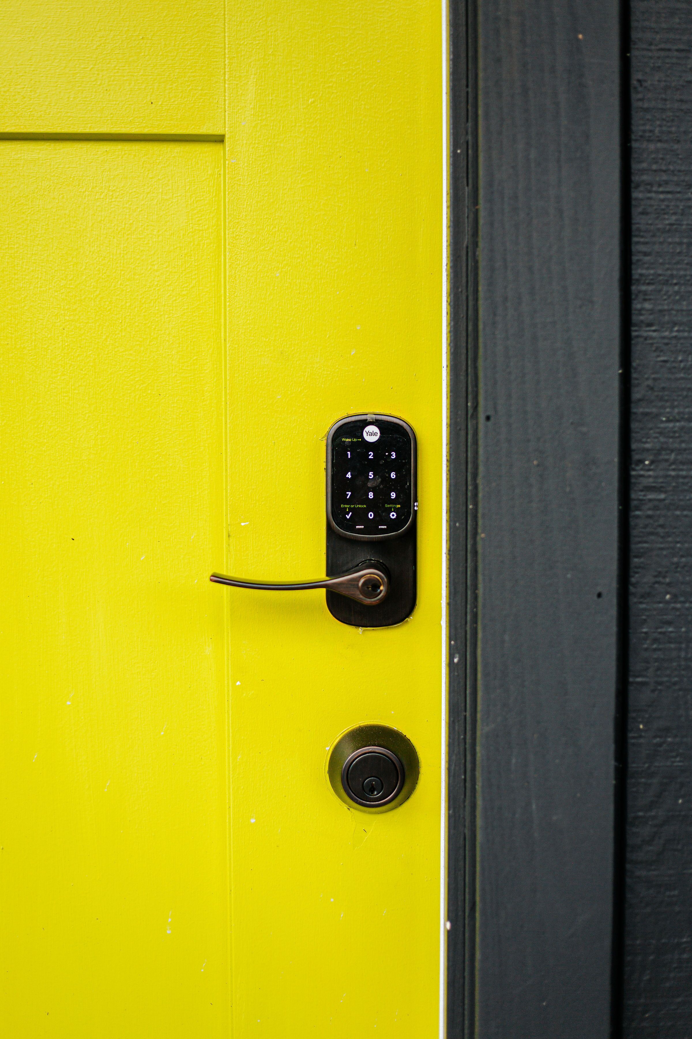 A yellow door with a Yale lockset and a keyhole.