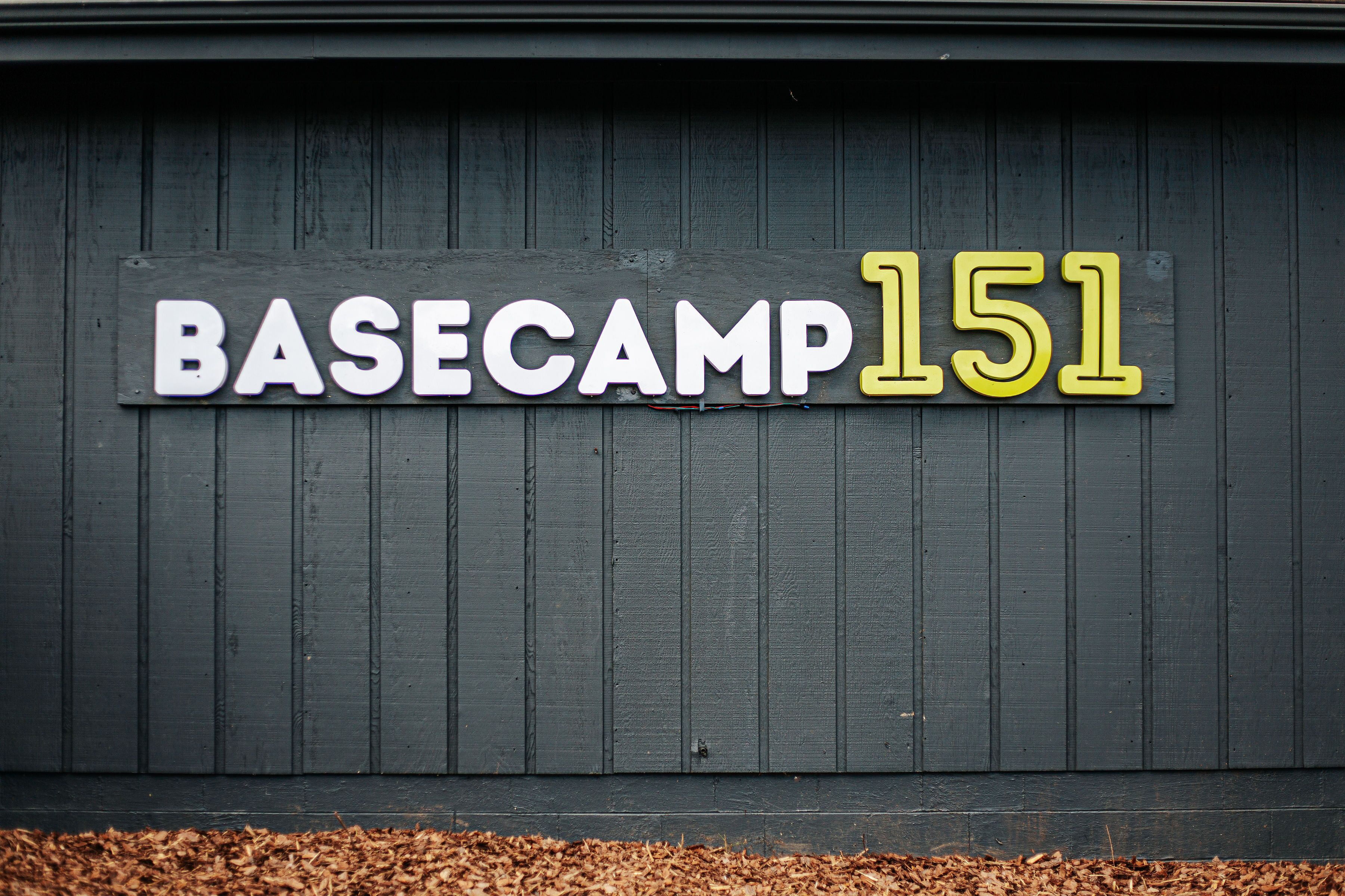 Un letrero con la inscripción 'BASECAMP 151' en una pared de madera.