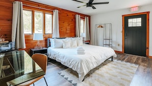 A bedroom with a bed, a desk, a chair, a ceiling fan, and an exit sign. - Basecamp151 (Afton)