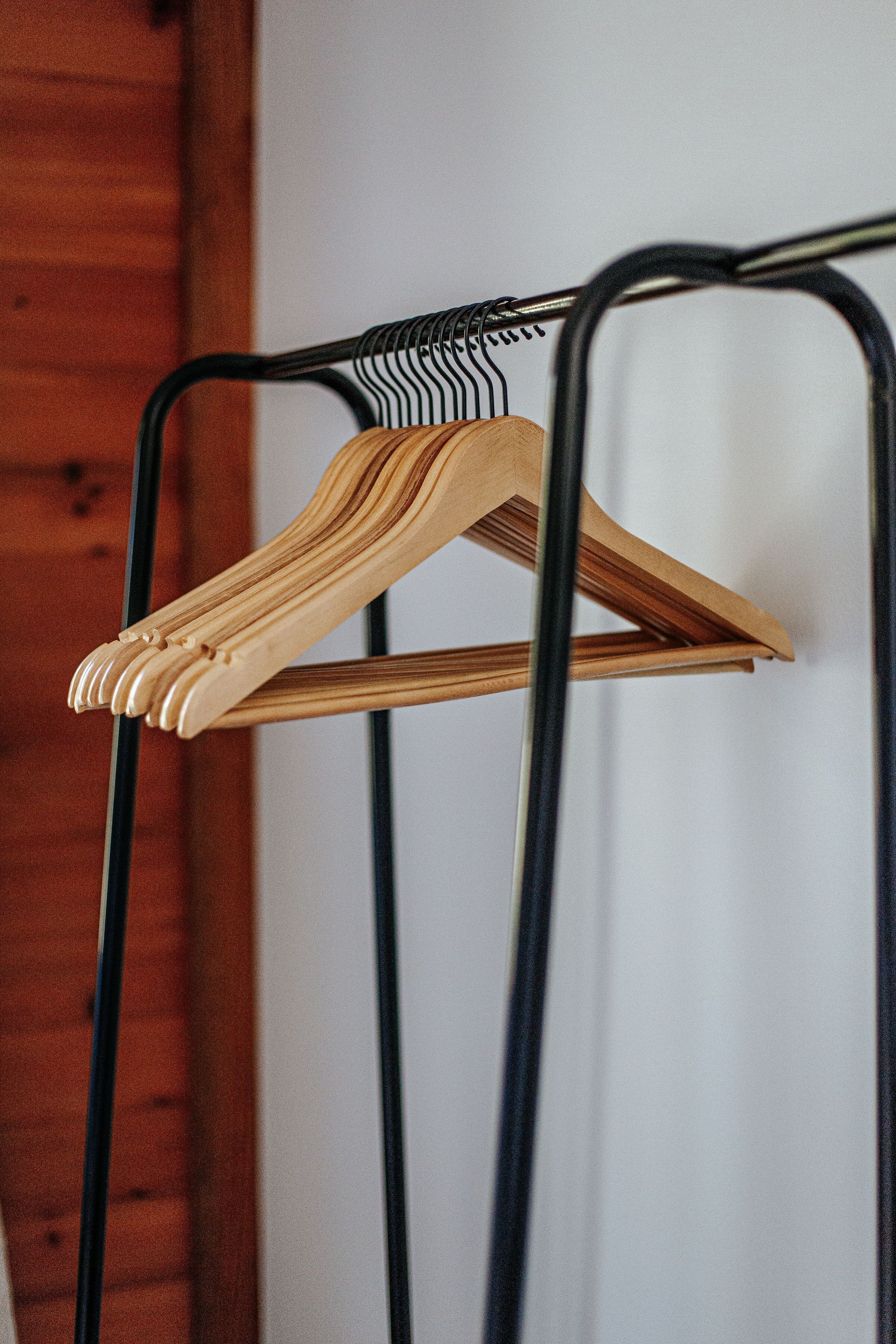 A metal hanger rack with wooden hangers.