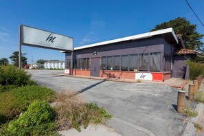 A modern building with a large sign for 'Monster Chef Fine Japanese Restaurant.' - @ Marbella Lane - Seaside Retreat Laundry + P (Half Moon Bay)
