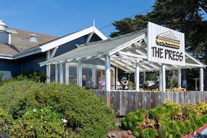 A building with a sign reading 'THE PRESS' and a covered outdoor seating area. - @ Marbella Lane - Seaside Retreat Laundry + P (Half Moon Bay)