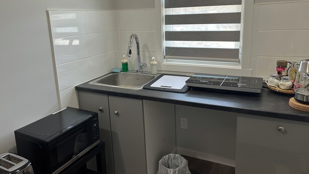 A compact kitchen with a sink, a microwave, and a toaster. - 1BR suite, fully private, no shared space, 20 mins from airport. (Edmonton)