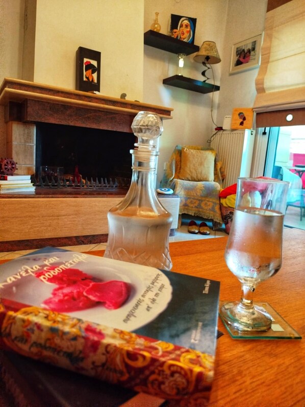 A dining table with a book, a glass of water, and a decorative bottle.