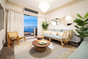 Un salon moderne avec un canapé, des fauteuils, une table basse et une grande plante en pot.