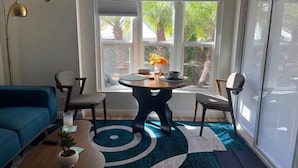 Ein modernes Wohnzimmer mit einem blauen Sofa, einem runden Couchtisch und einem Blumentopf.