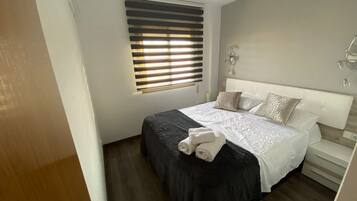 2 dormitorios, tabla de planchar con plancha, ropa de cama