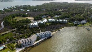A coastal hotel with multiple buildings, a dock, and a body of water.