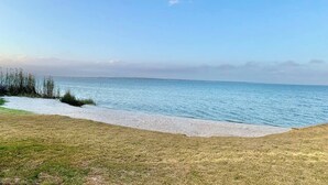 Een strand met een heldere lucht en rustig water.
