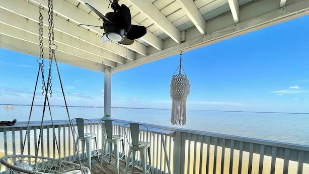 Een overdekt terras met een hangstoel, een hanglamp en een decoratieve lantaarn.