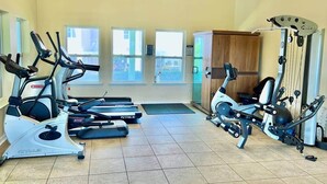 A gym with treadmills, elliptical machines, and a rowing machine.