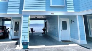 A two-story residential building with a garage entrance and a visible address number. - Serenita Ora: Quiet Waterfront Unit with 2 Kayaks! (Pensacola)