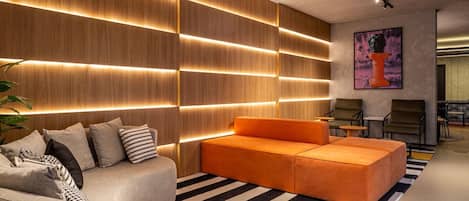 A modern living room with a sectional sofa, a grey armchair, and a striped rug.