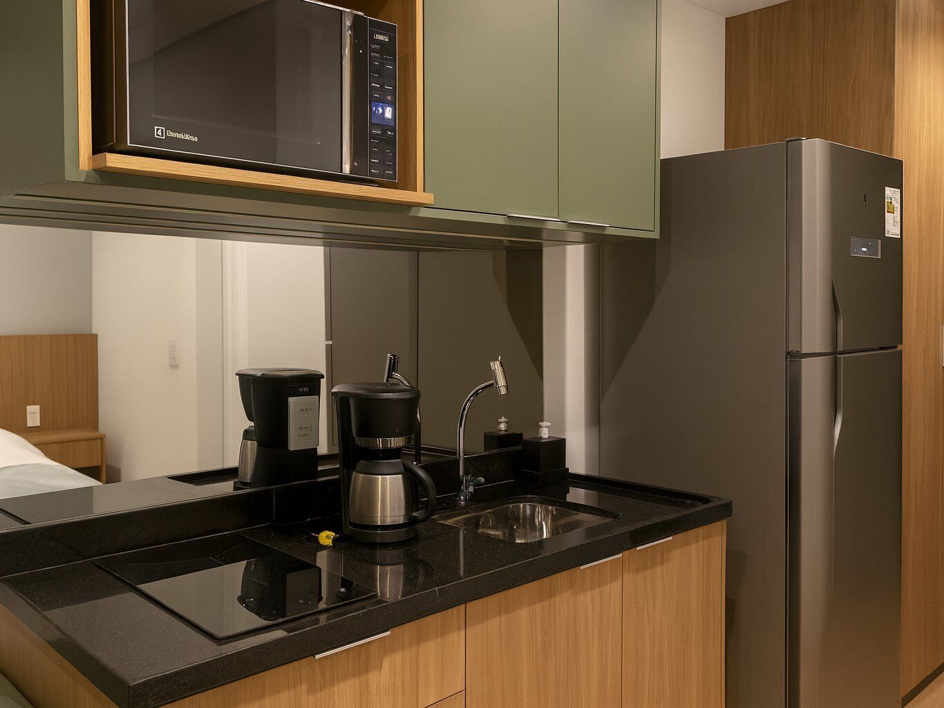A modern kitchen with a built-in microwave, coffee maker, and refrigerator.