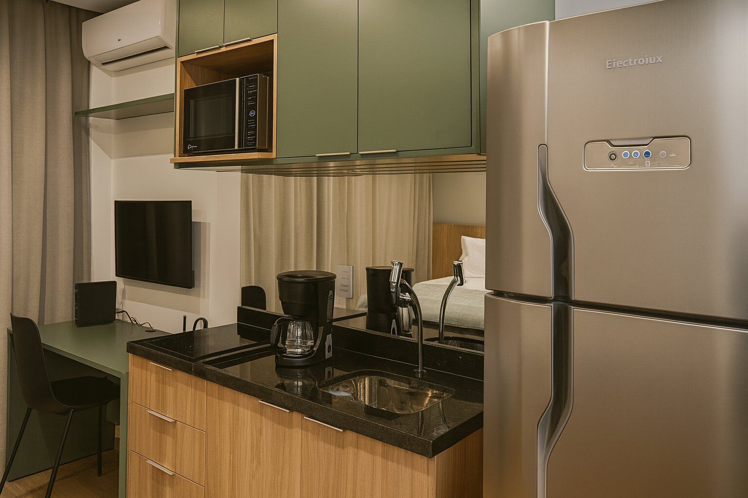 A compact kitchenette with a microwave, coffee maker, and a refrigerator.