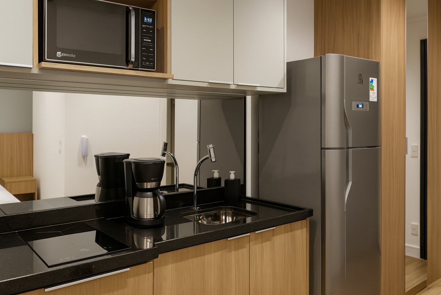Una cucina moderna dotata di forno a microonde, macchina del caffè e frigorifero in acciaio inossidabile.