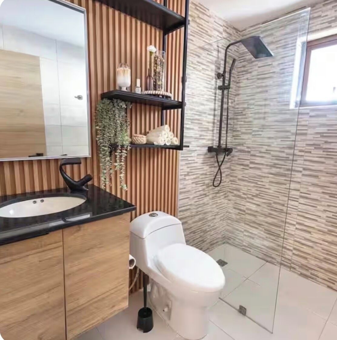 Une salle de bain moderne avec un meuble-lavabo en bois, des toilettes blanches, une douche en verre et un miroir.
