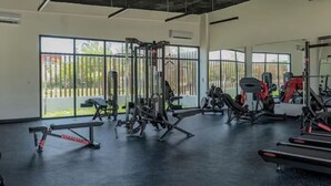 A gym with various exercise machines, large windows, and a black floor. - Punta Cana Beach Retreat-Costa Bavaro (Punta Cana)