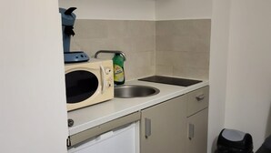 A compact kitchen with a microwave, sink, and a small refrigerator. - Bel air flat (Villeneuve-Loubet)