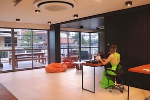 Un espace de bureau moderne avec une grande fenêtre, une chaise verte et un bureau.