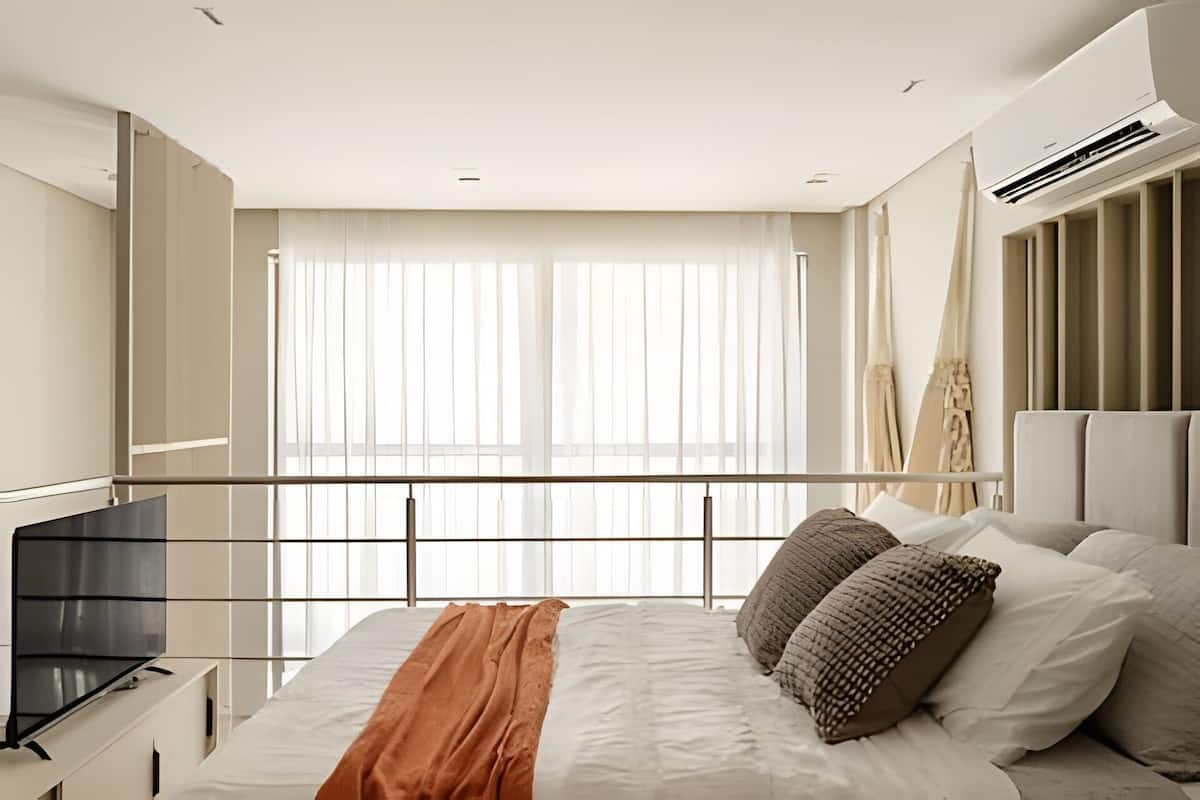 Une chambre d’hôtel moderne dotée d’un grand lit, d’une télévision et d’un balcon avec des rideaux.