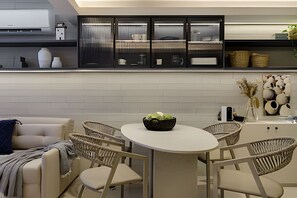 Une cuisine moderne avec une table de salle à manger ronde, des chaises en osier et un canapé.