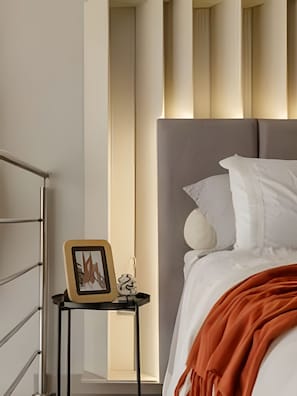 A bedroom with a bed, a nightstand, and a framed picture.