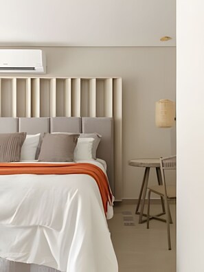 Une chambre d’hôtel moderne avec un grand lit, une table de chevet et un appareil de climatisation.