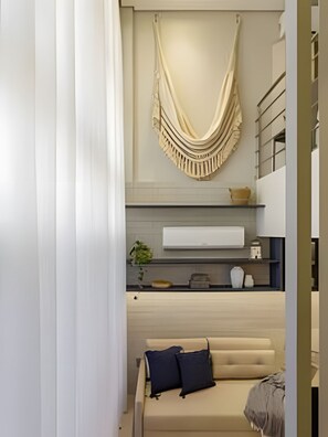 A modern bedroom with a bed, a hanging textile, a white bedside table, and a built-in shelf with decorative items. - Box 150 (Joao Pessoa)